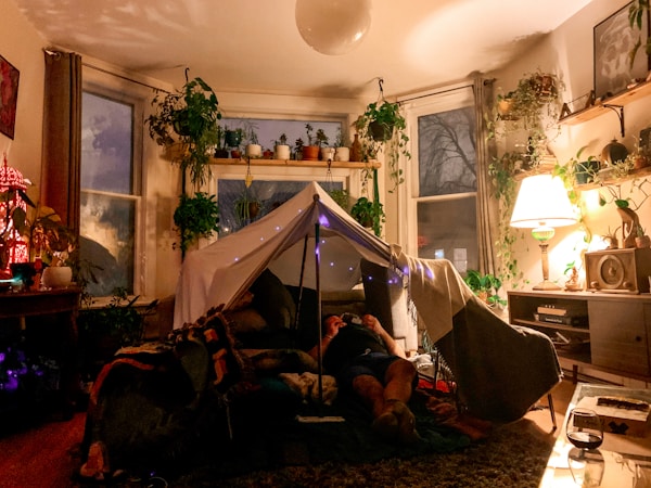 man lying on bed near white tent