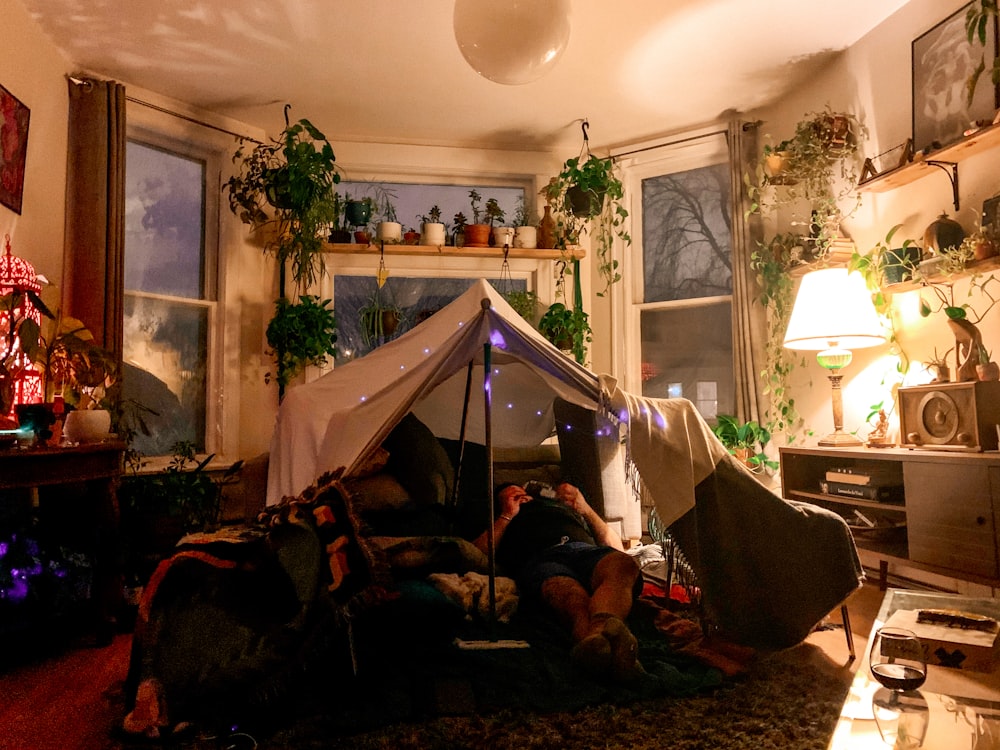 man lying on bed near white tent