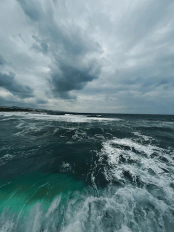 A wide view of the stormy coastline with dark clouds rolling over the sea.