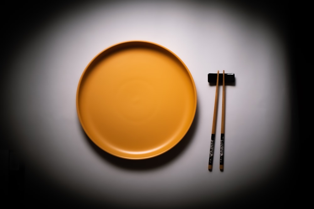 bâtonnets en bois brun sur plaque ronde en céramique jaune