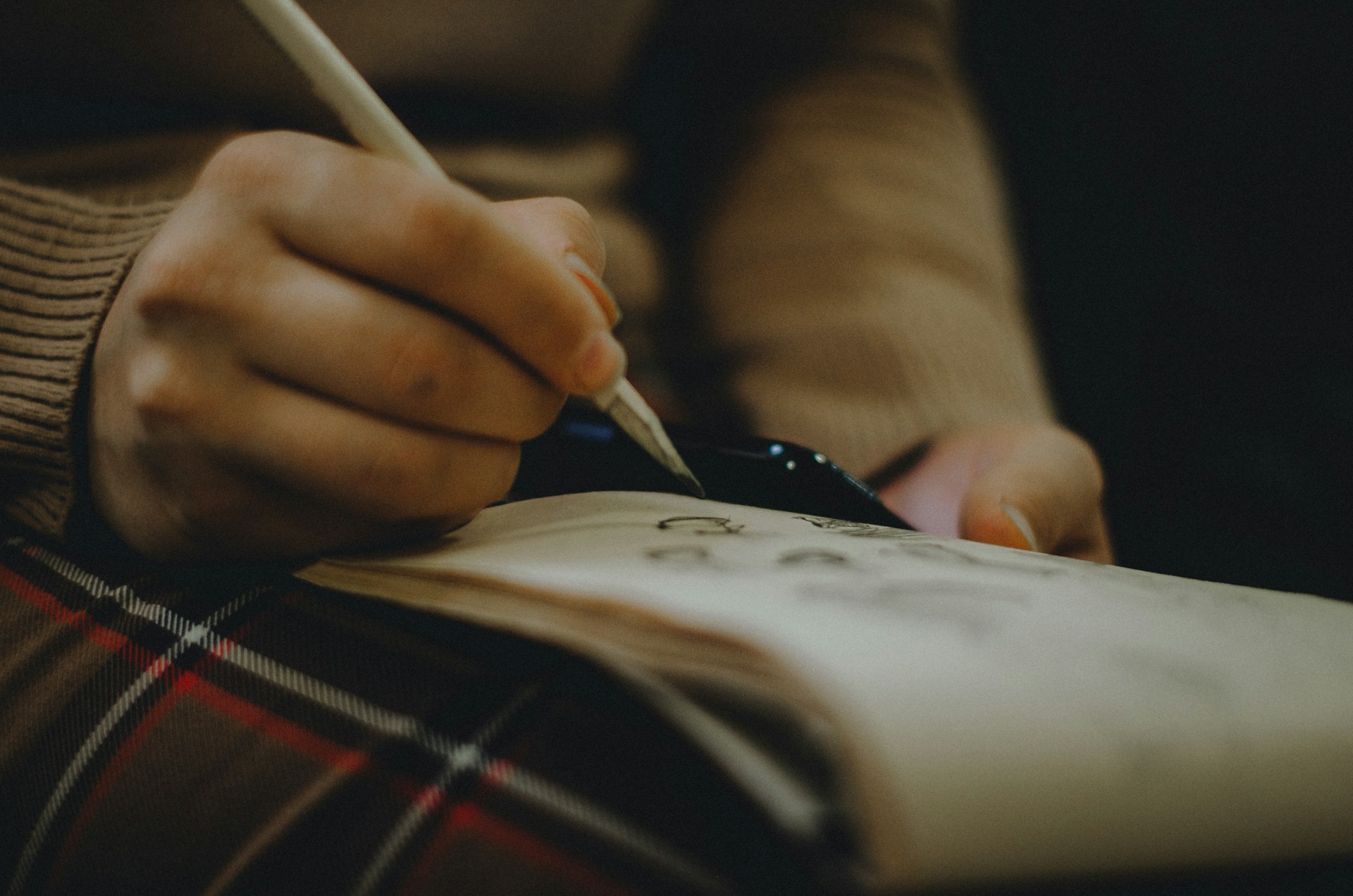 person holding pen and book