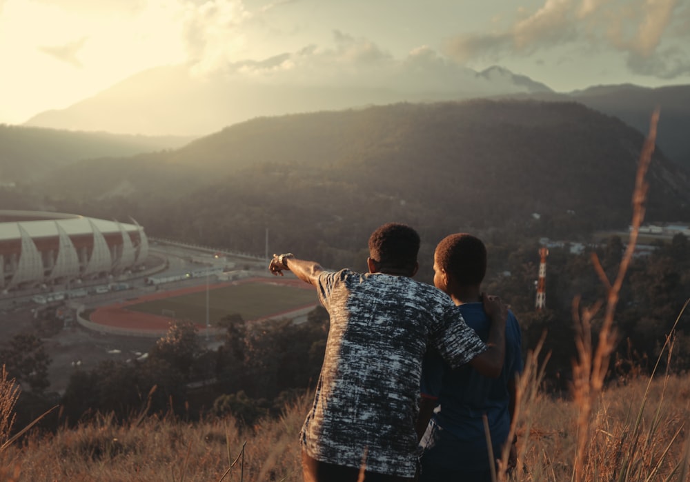 man and woman standing on top of mountain during daytime