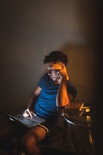man in blue crew neck t-shirt sitting on chair