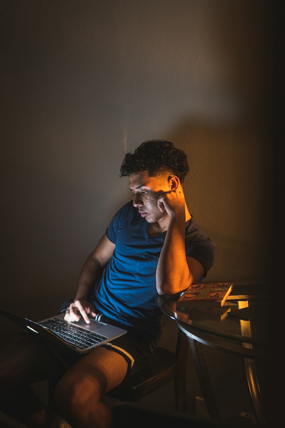 man in blue crew neck t-shirt sitting on chair