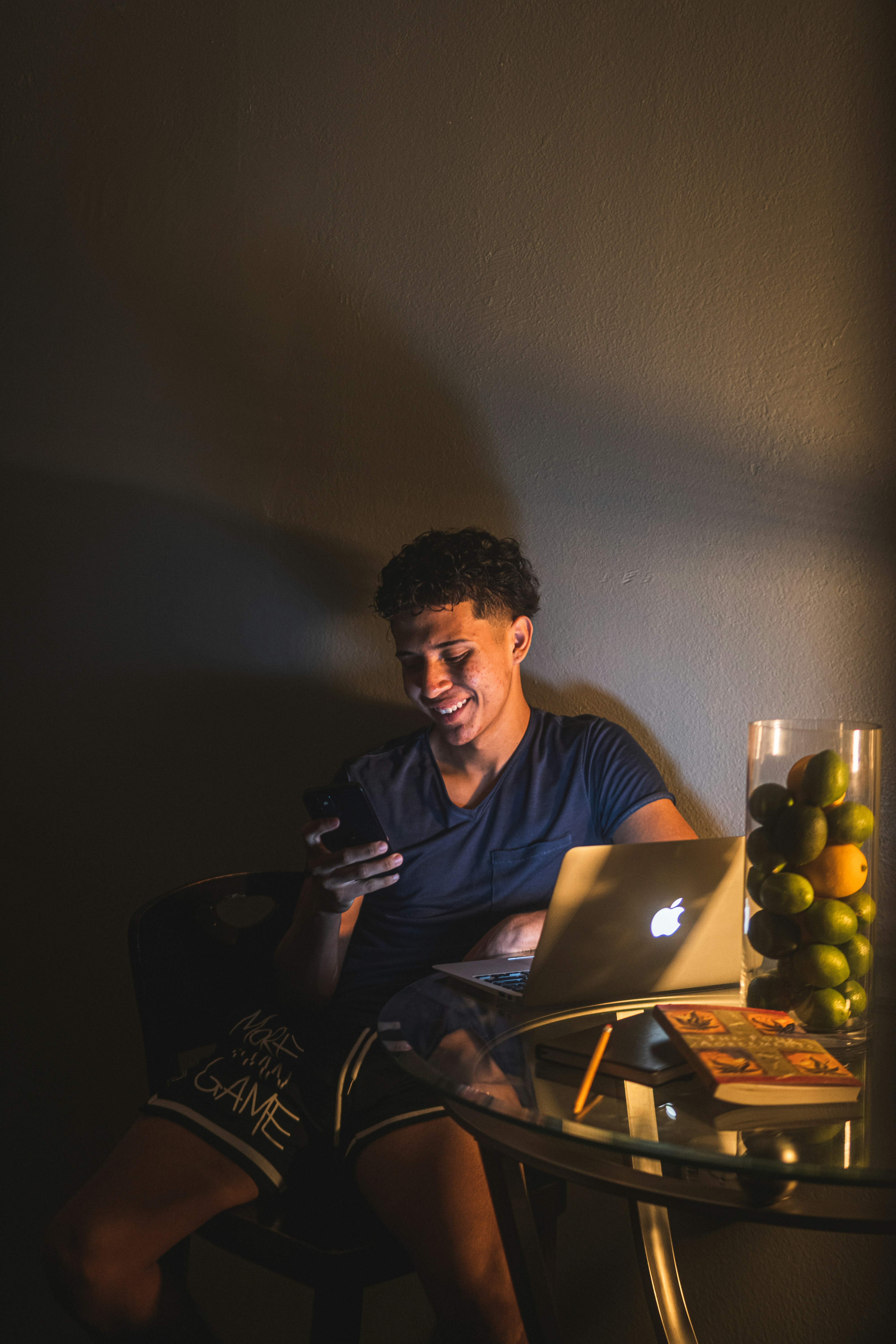 Mann in schwarzem Rundhals-T-Shirt sitzt auf Stuhl vor Laptop