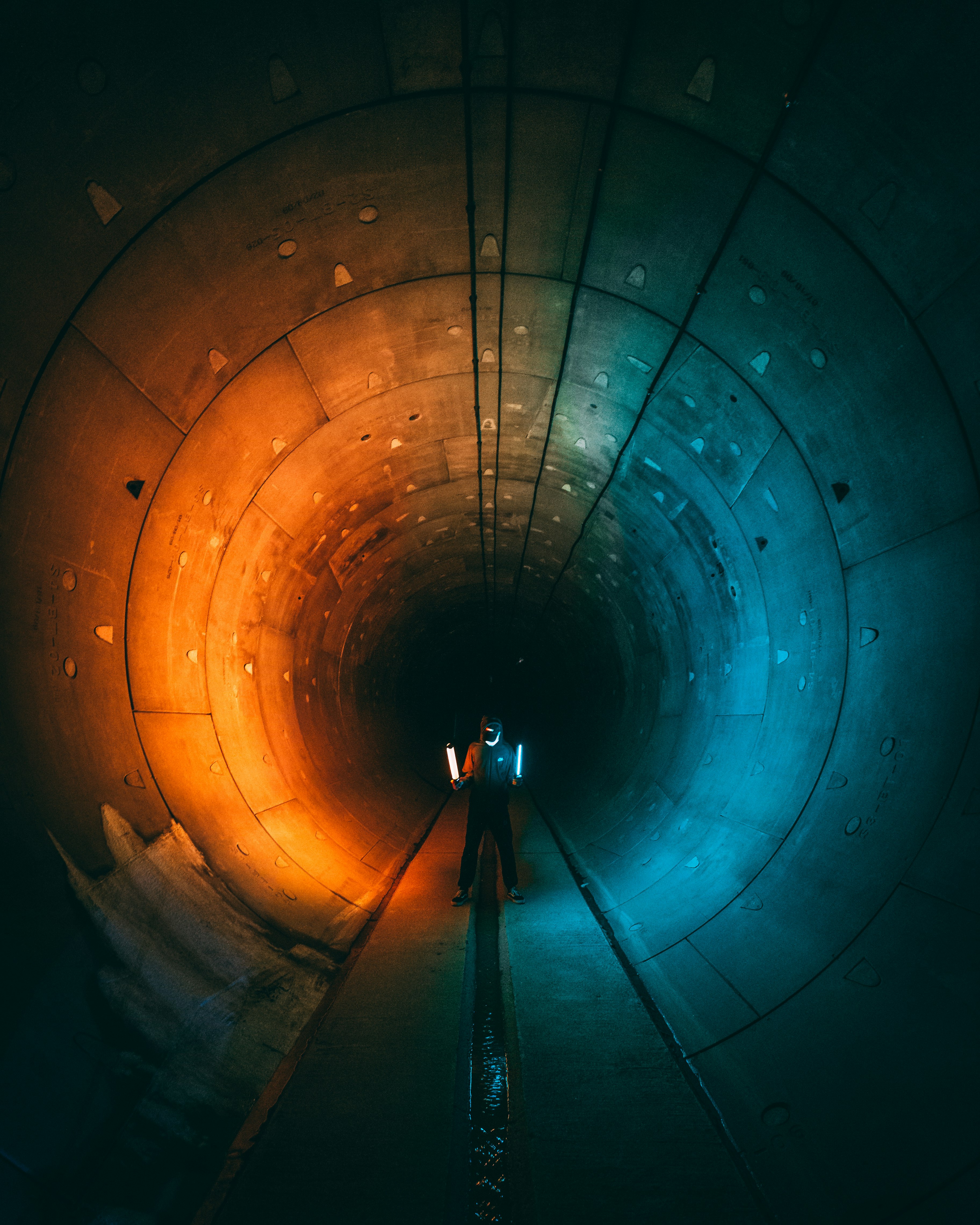 man in black jacket standing on tunnel