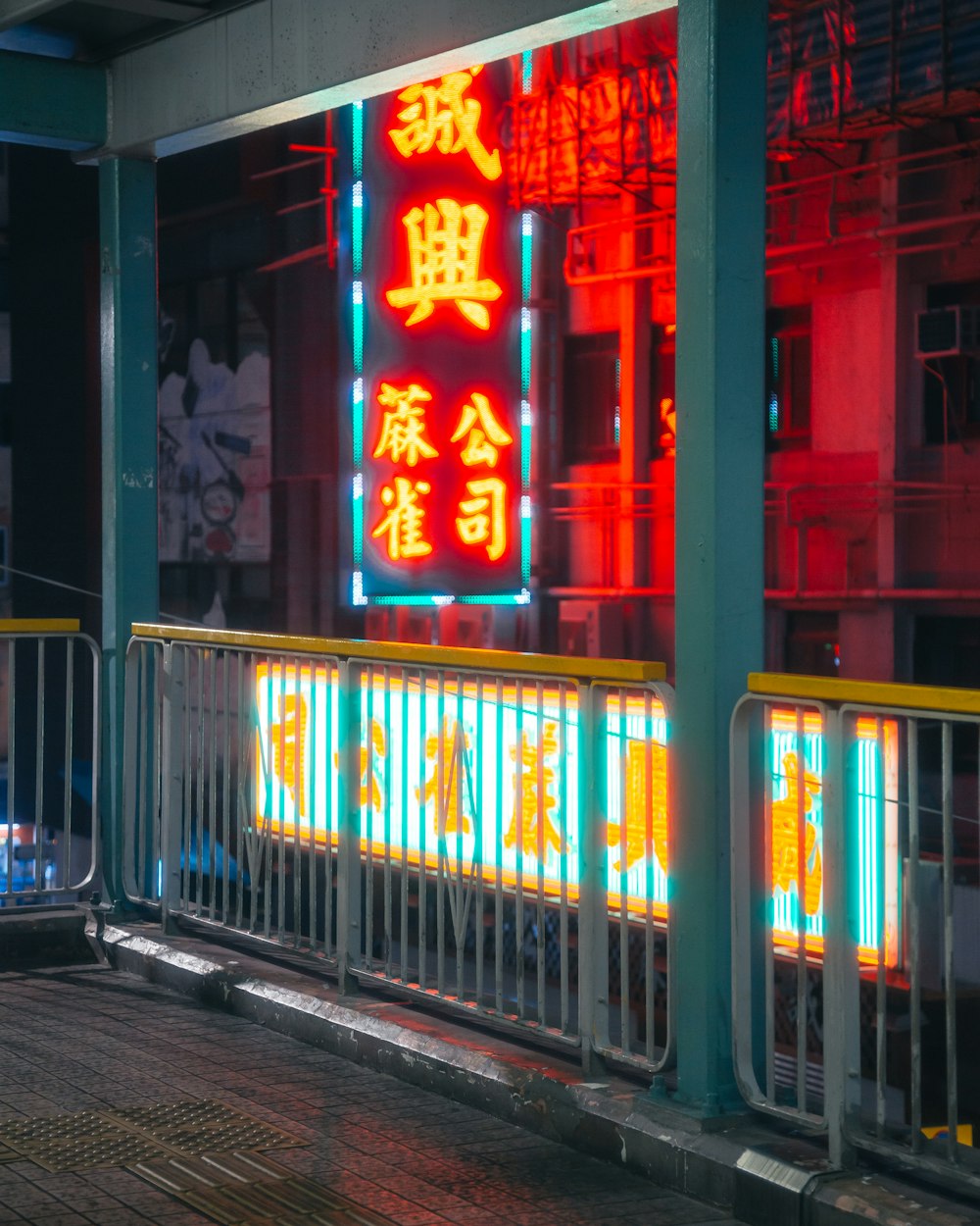 blue metal railings near red neon light signage