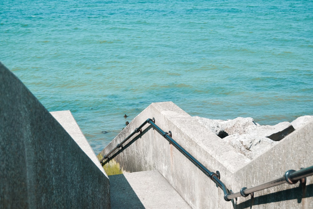 gray concrete dock near body of water during daytime