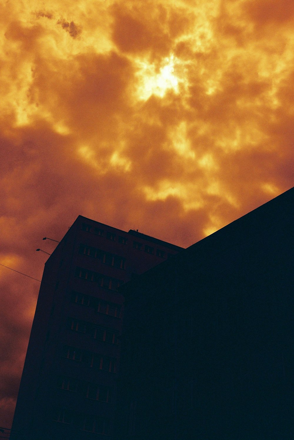 silhouette of building under orange clouds