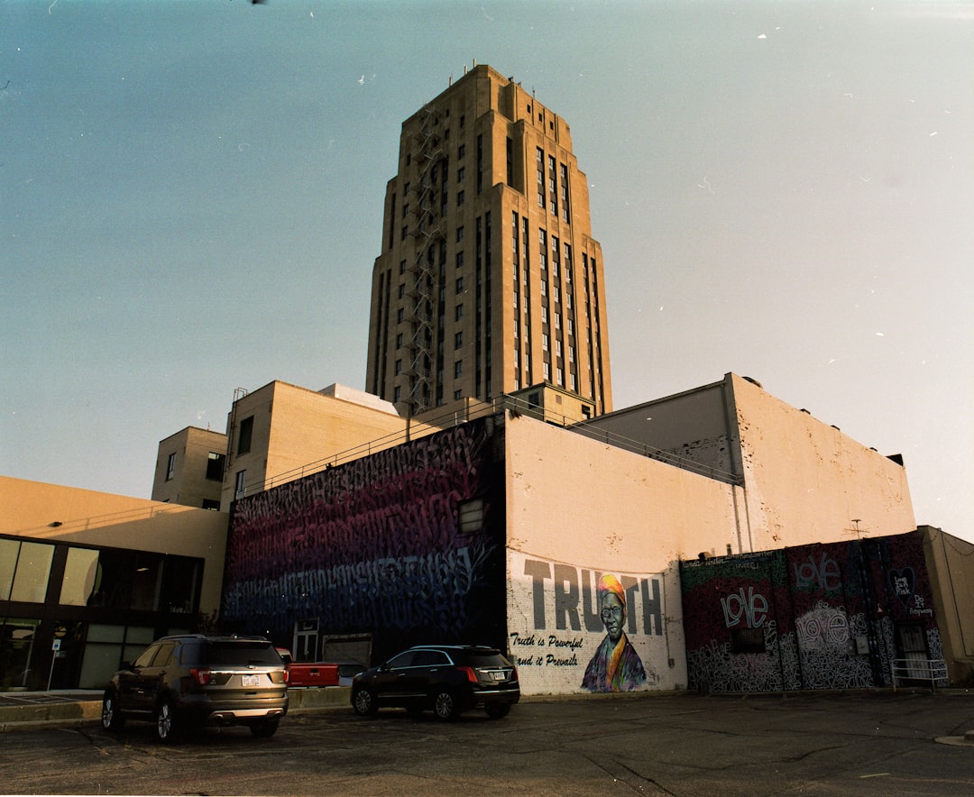 cars parked beside brown concrete building during daytime