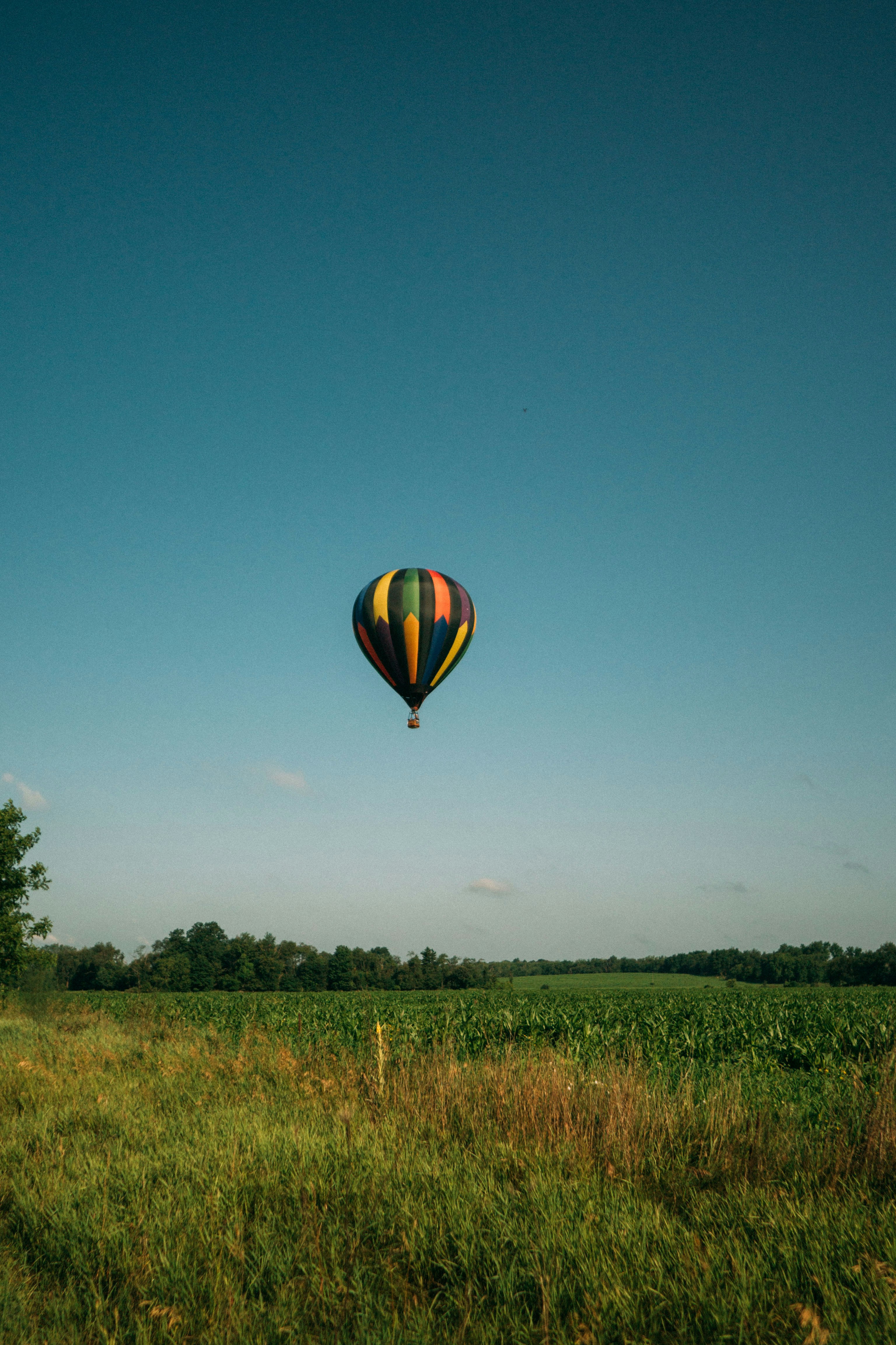 yellow blue and green hot air balloon in mid air during daytime