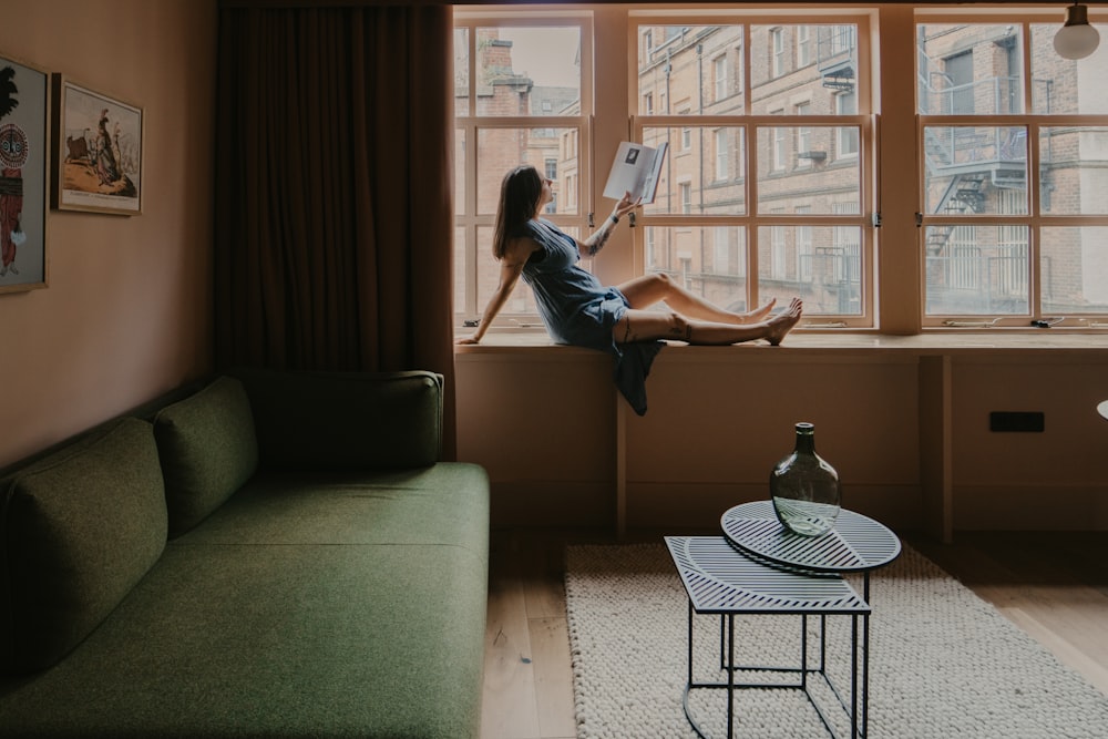 woman in blue denim jeans sitting on gray couch