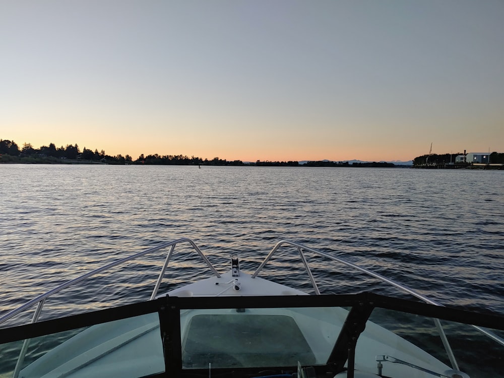 white boat on sea during sunset