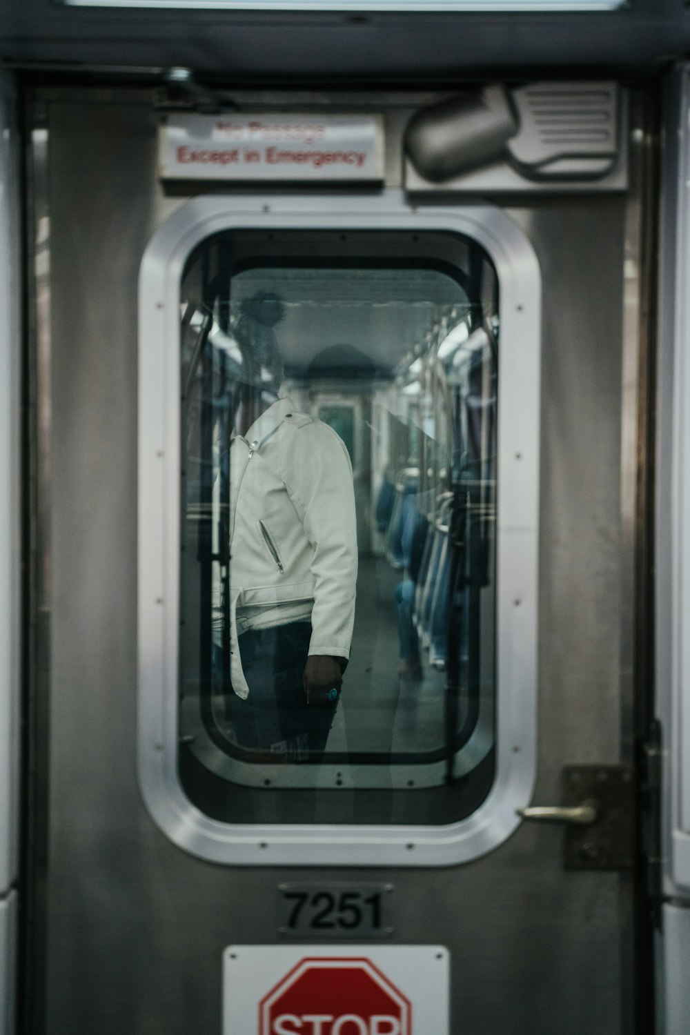 man in white dress shirt sitting on train seat