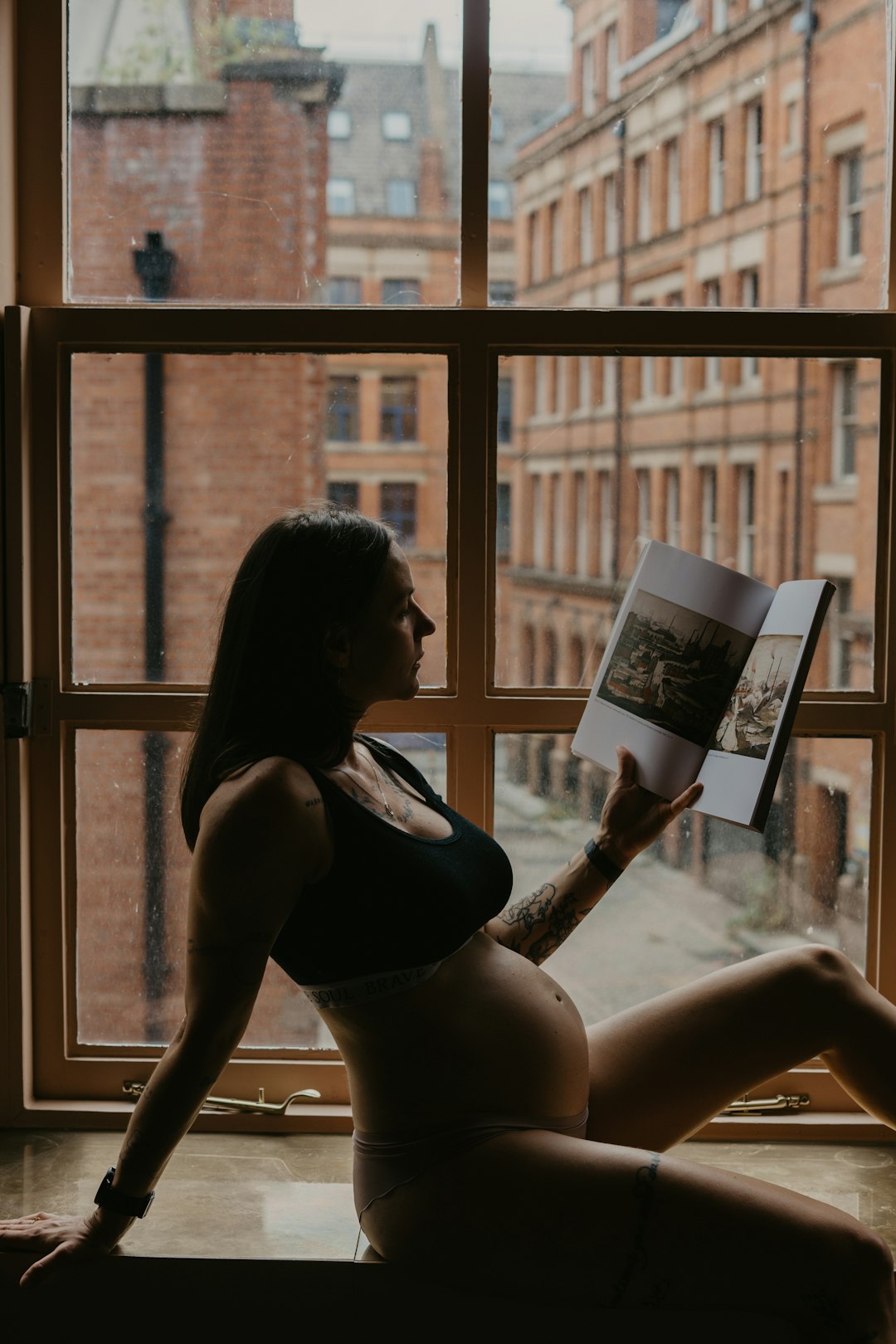woman in black sports bra reading book