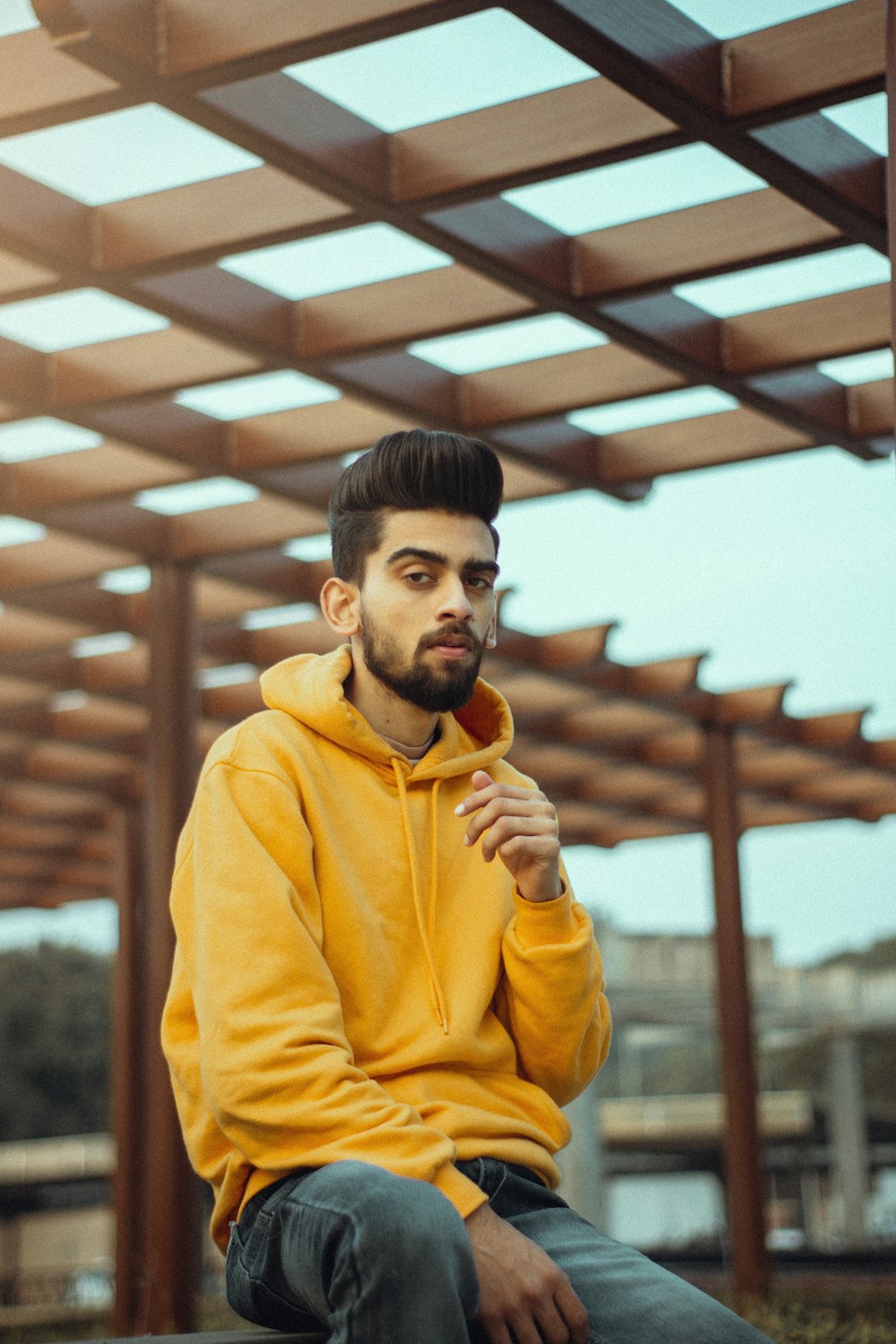 man in yellow hoodie holding brown bread