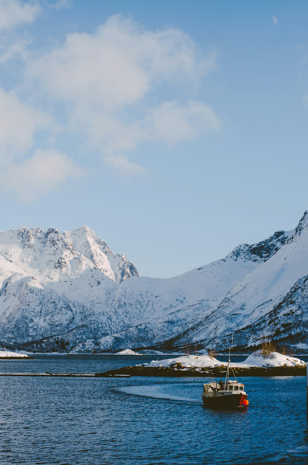 a boat in a body of water with mountains in the background