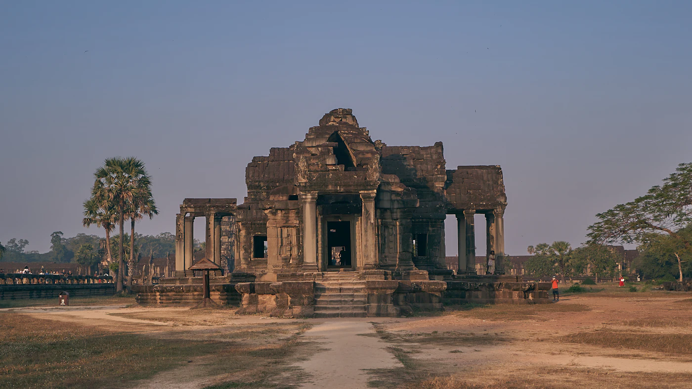 Ancient stone temple towers at Angkor under a bright blue sky