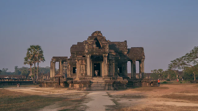 Ancient stone temple towers at Angkor under a bright blue sky