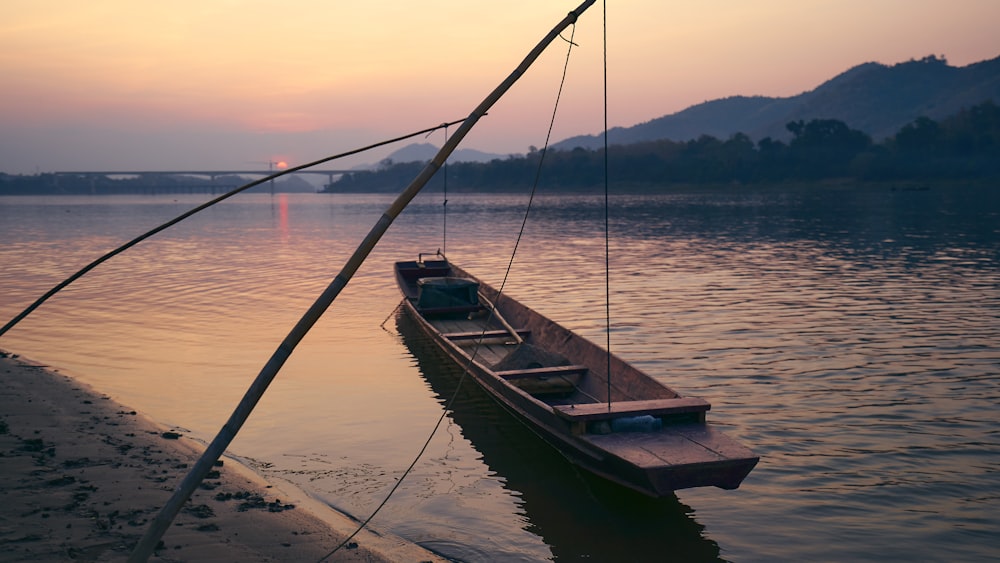 brown wooden boat on sea shore during daytime