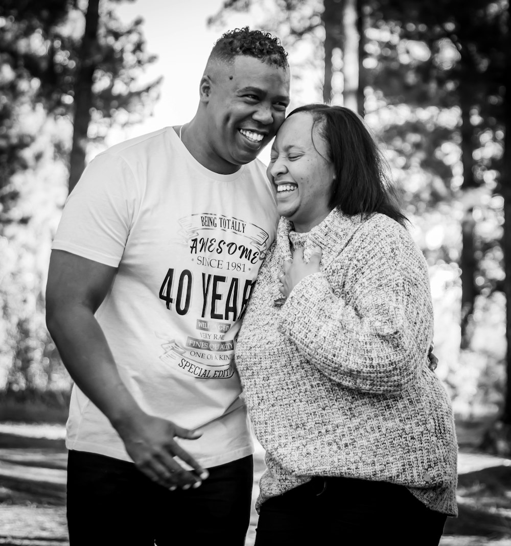 man in white crew neck t-shirt standing beside woman in black and white polka dot