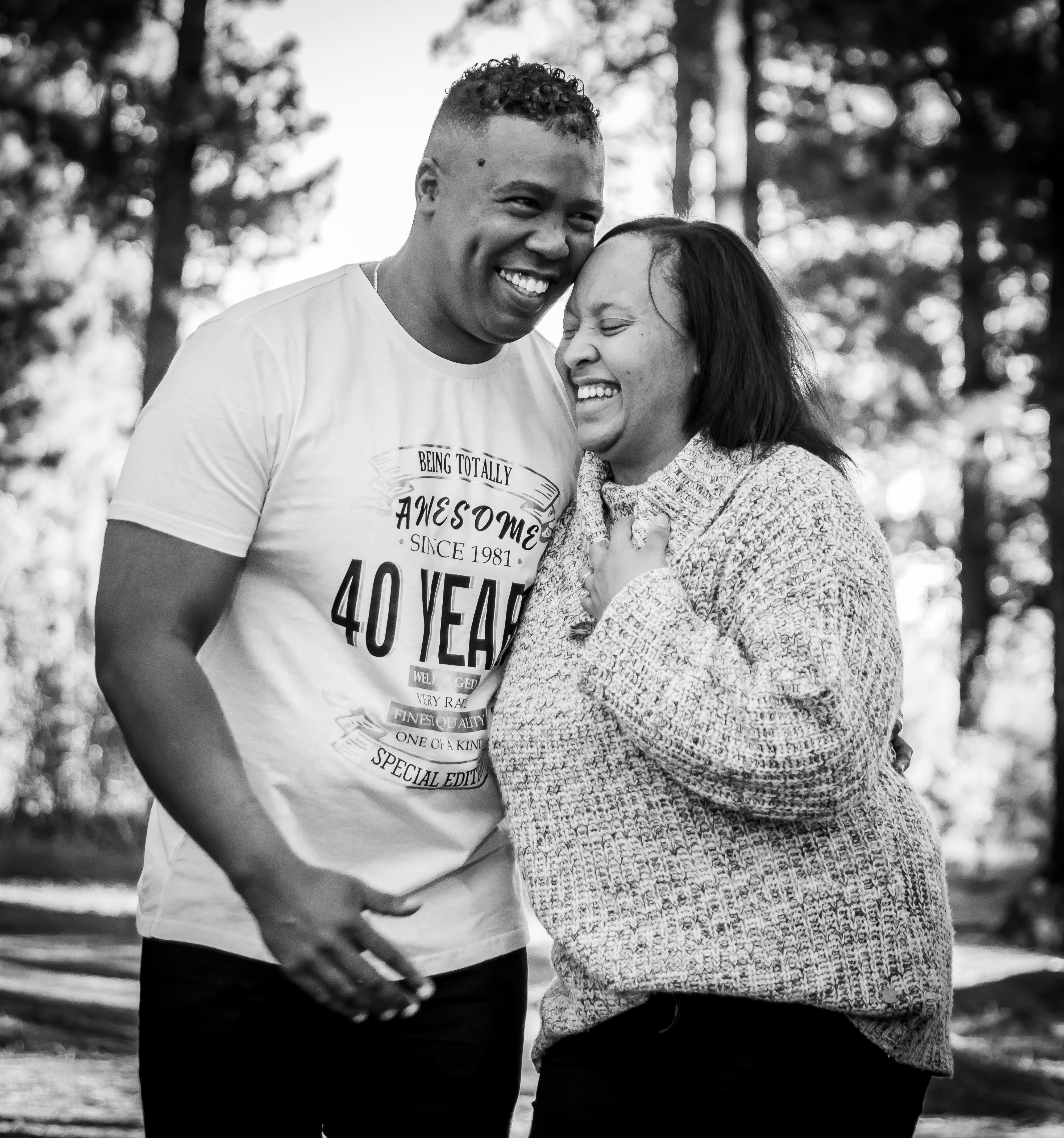 man in white crew neck t-shirt standing beside woman in black and white polka dot