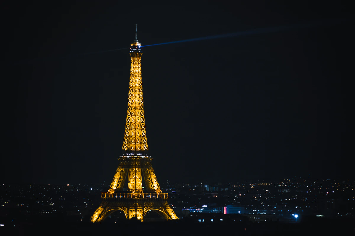 Eiffel Tower lit up at night against dark sky