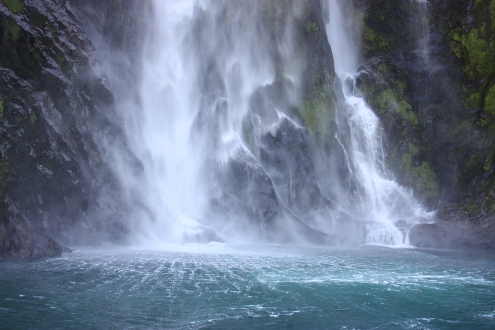 water falls on green grass field during daytime