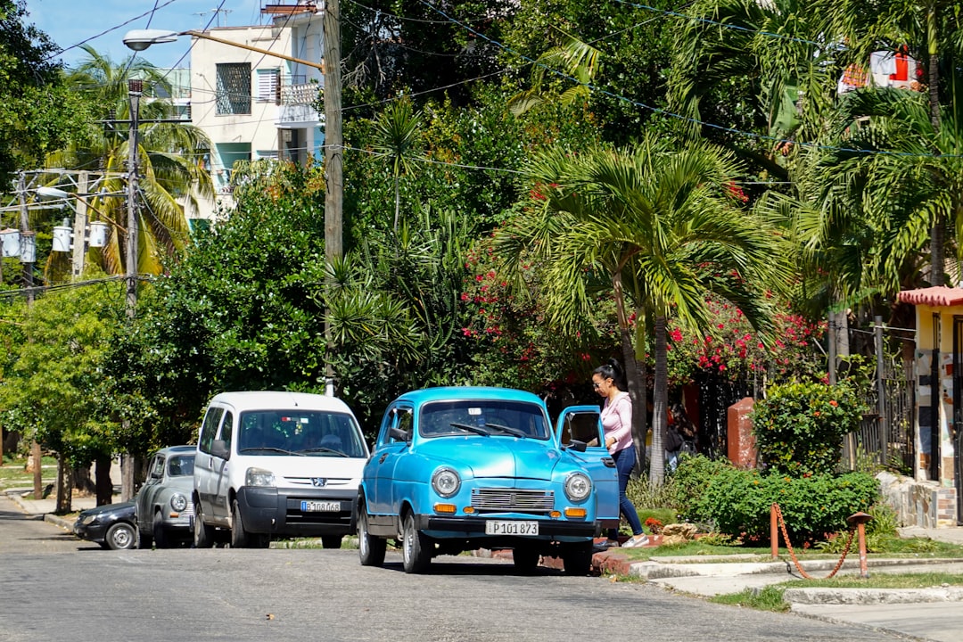 blue volkswagen beetle parked beside white car during daytime