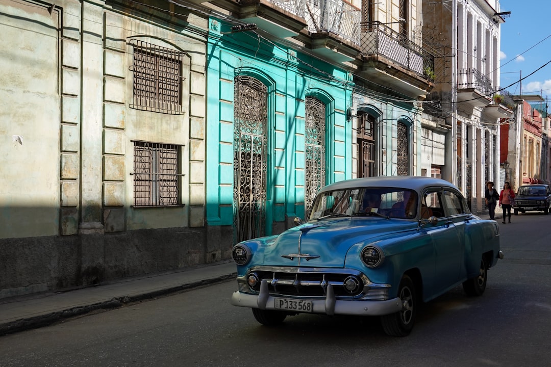 blue car parked beside building during daytime