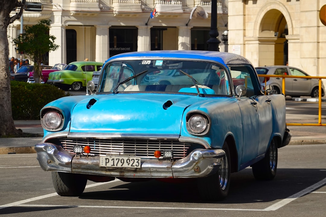 blue classic car parked near building during daytime