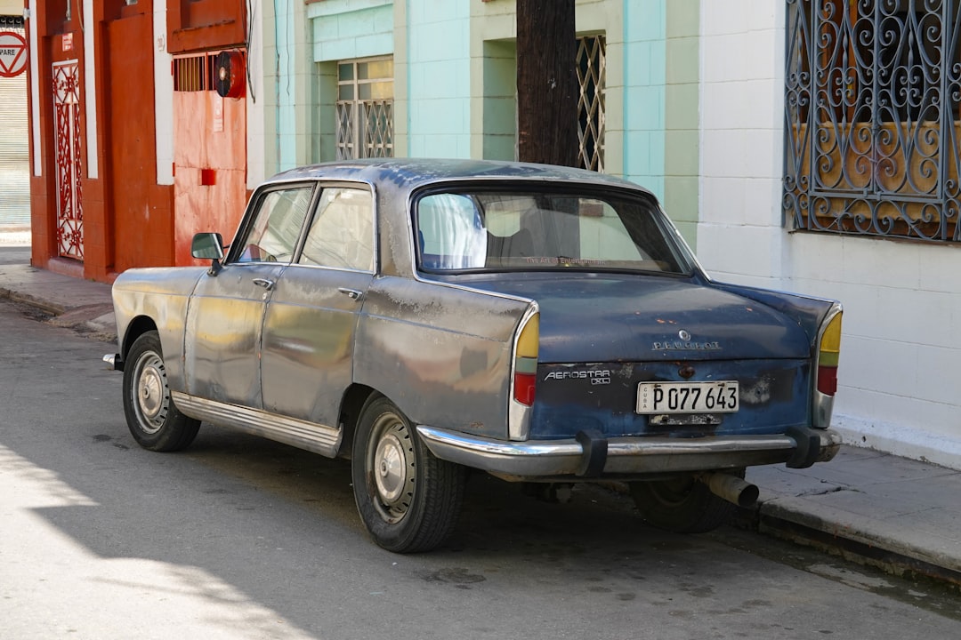 blue sedan parked beside red and white building