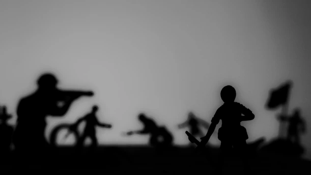 Silhouetted toy soldiers are positioned in various action poses, suggesting a battle scene. The composition is monochrome, creating a dramatic and intense atmosphere.