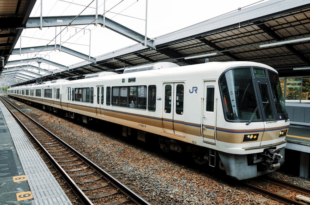 white and green train on rail tracks