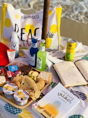 Close-up of delicious beach snacks and lanches served on a colorful tablecloth.