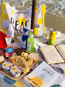 A scenic beach scene with a picnic setup featuring travel-friendly snacks and drinks.