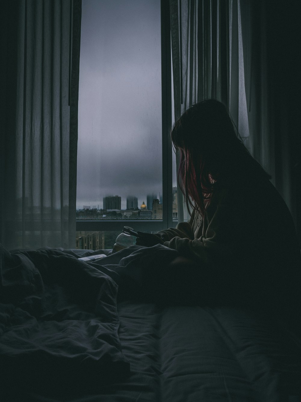 silhouette of woman sitting on bed