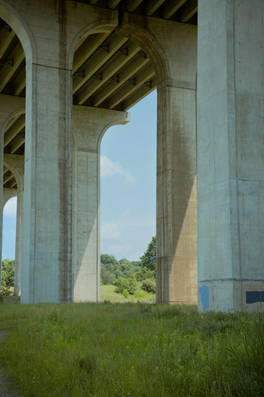 gray concrete bridge over green grass field during daytime