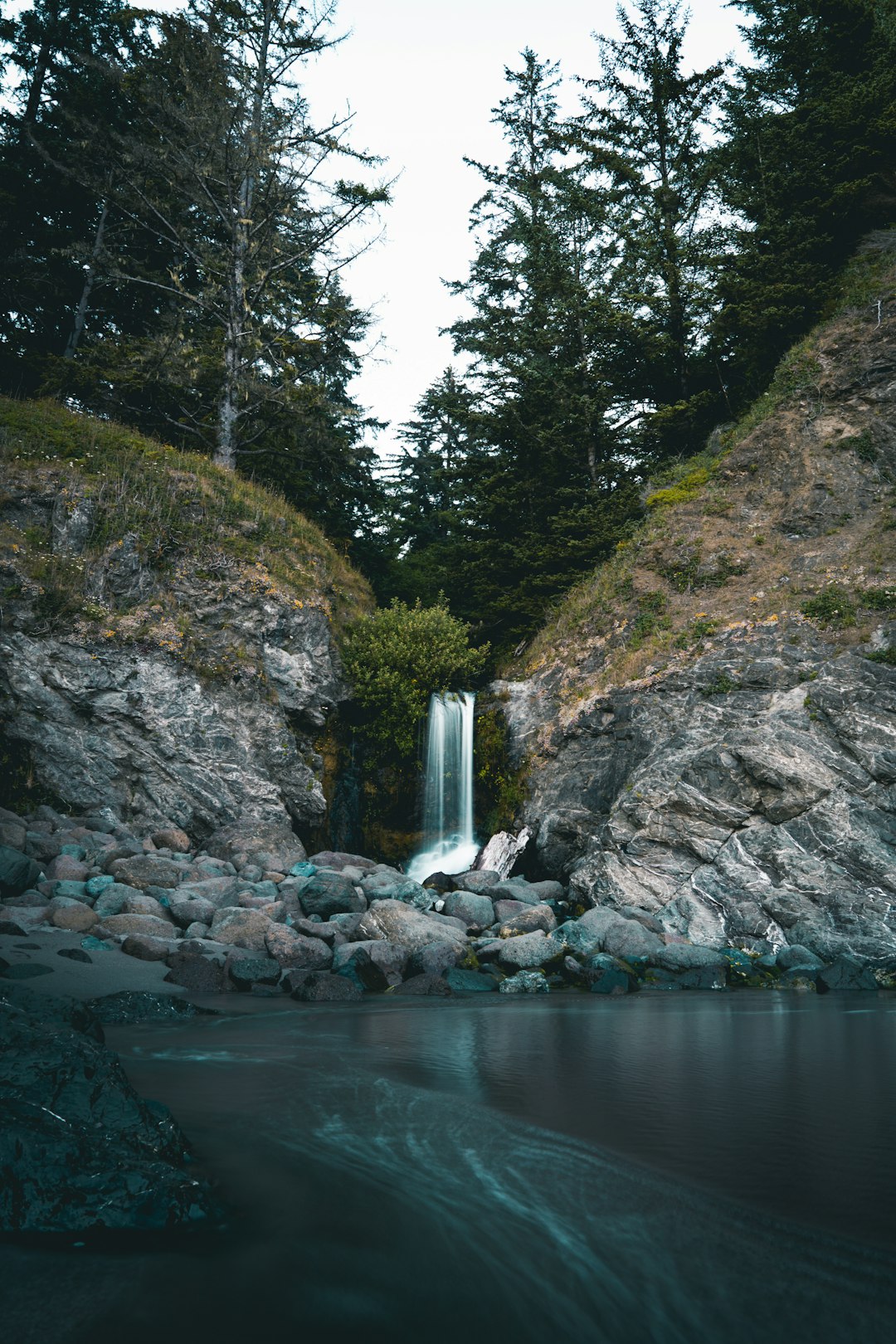 waterfalls on brown rocky mountain during daytime