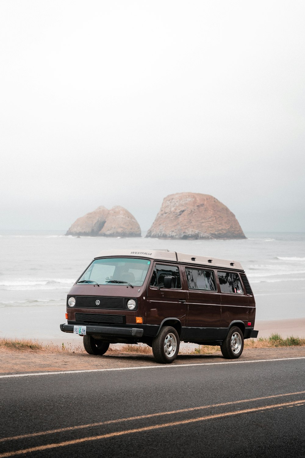 red suv on brown sand near body of water during daytime