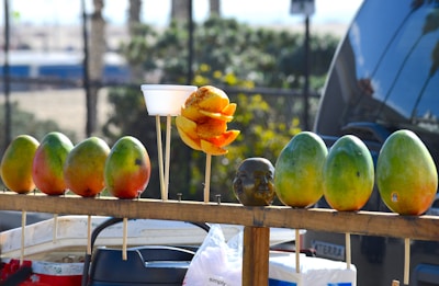 Fresh organic mangoes and spices arranged on a rustic wooden table.