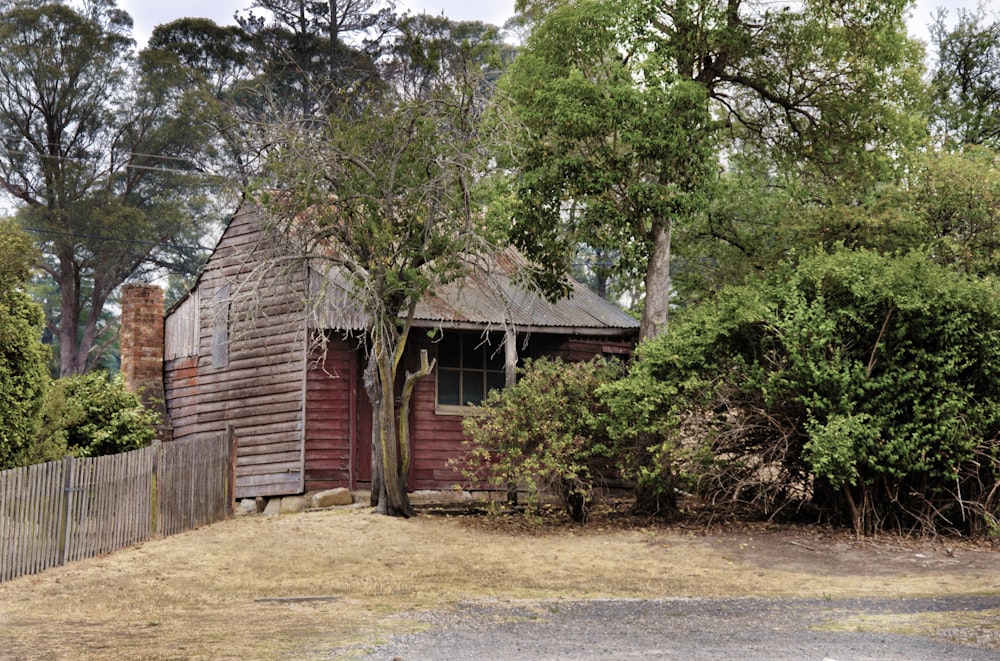 brown wooden house near green trees during daytime