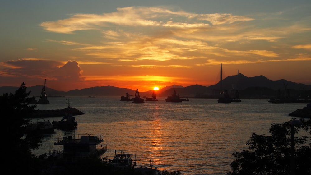 silhouette of boat on sea during sunset