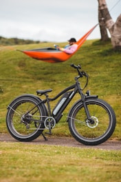 black and orange bicycle on green grass field during daytime
