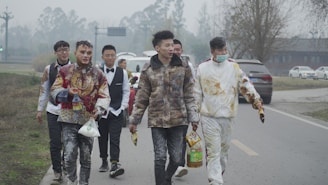 A group of young men wearing stylish streetwear walking down an urban street.