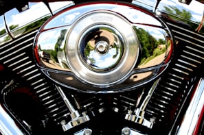 A close-up of a vintage motorcycle's shiny chrome engine reflecting sunlight