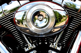 A close-up of a vintage motorcycle's shiny chrome engine reflecting sunlight