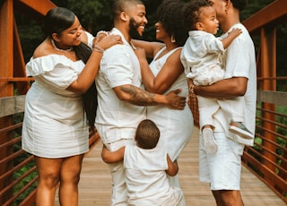 man in white dress shirt carrying baby in white dress