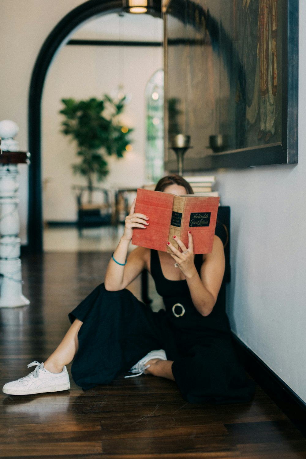 woman in black dress holding brown leather bag