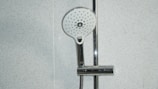 stainless steel shower head on white ceramic tiles